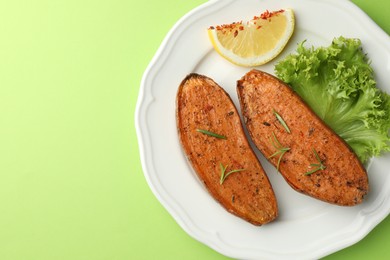 Tasty baked sweet potato served on green table, top view. Space for text