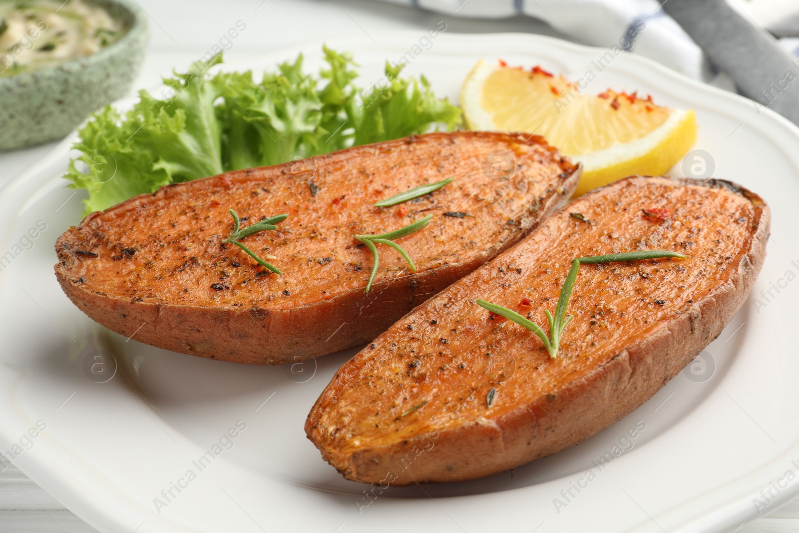 Photo of Tasty baked sweet potato served on white table, closeup