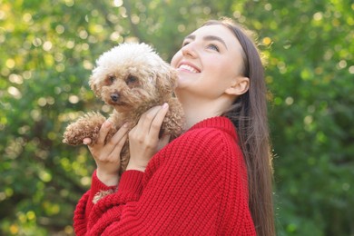 Photo of Portrait of smiling woman with cute dog outdoors