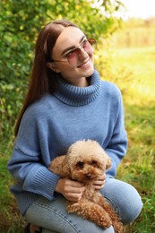 Photo of Smiling woman with her cute dog outdoors