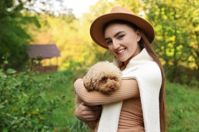 Photo of Smiling woman with cute dog outdoors. Space for text