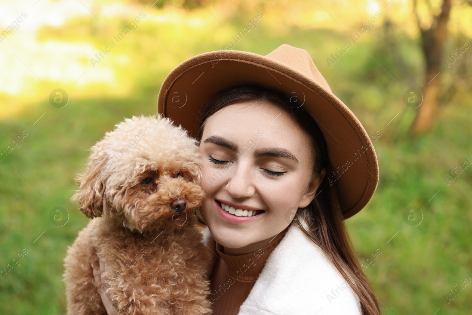 Photo of Portrait of smiling woman with cute dog outdoors