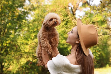 Smiling woman with cute dog in autumn park. Space for text