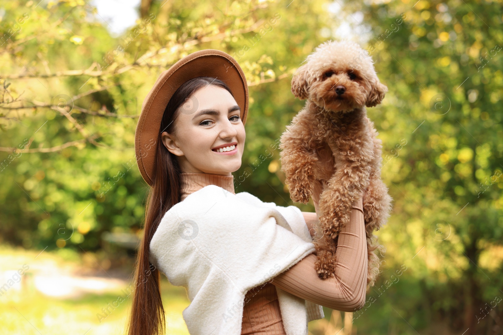 Photo of Smiling woman with cute dog in autumn park