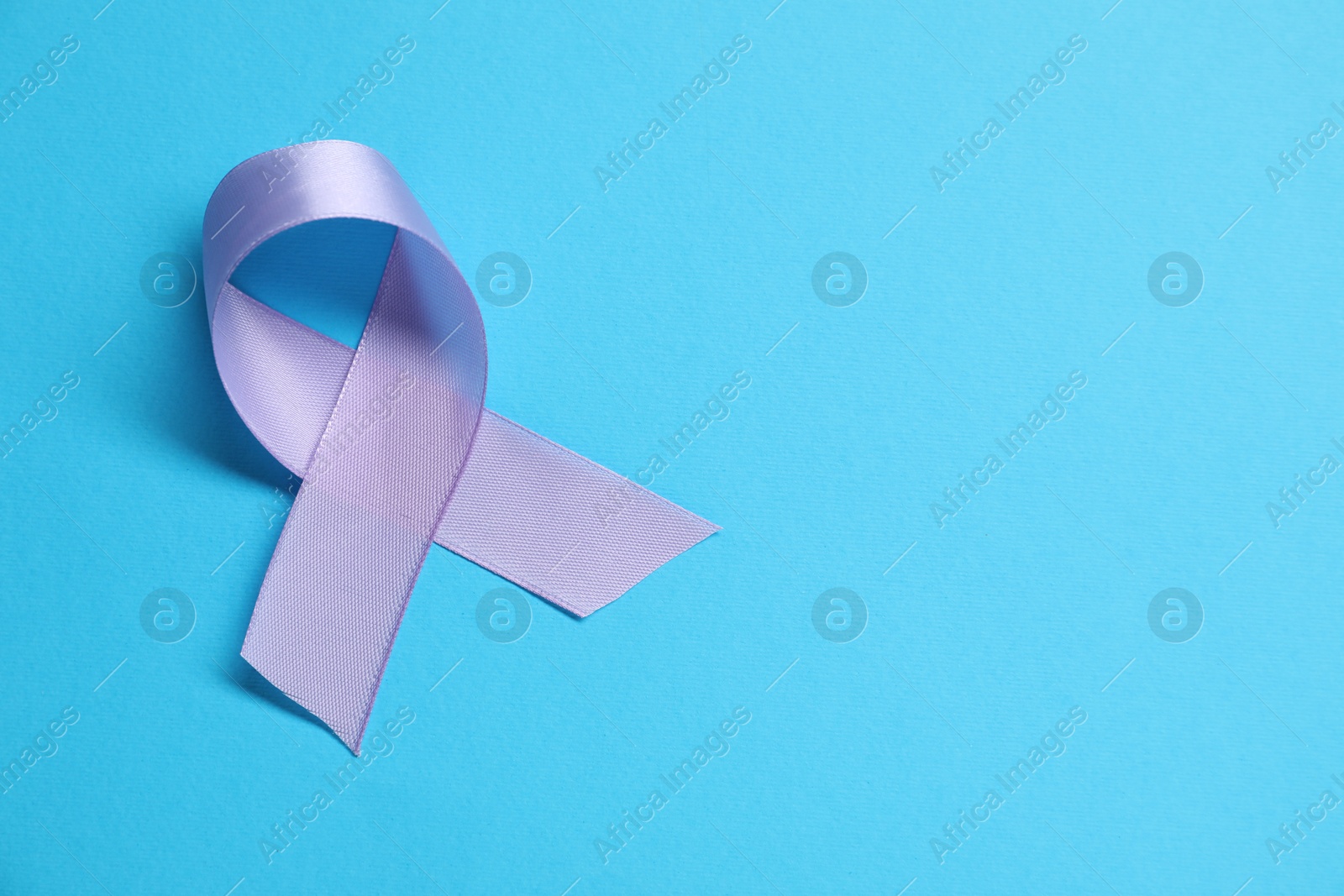 Photo of Violet awareness ribbon on light blue background, top view. Space for text