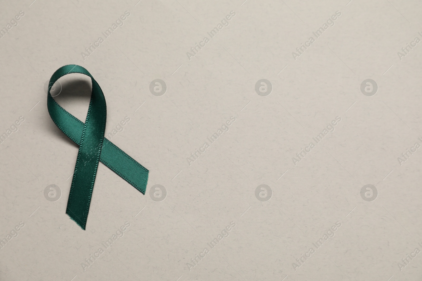 Photo of Green awareness ribbon on gray background, top view. Space for text