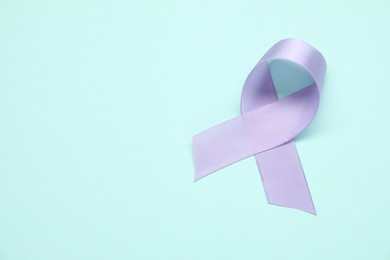 Violet awareness ribbon on light blue background, top view. Space for text