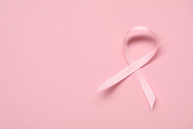 Photo of Pink awareness ribbon on color background, top view. Space for text