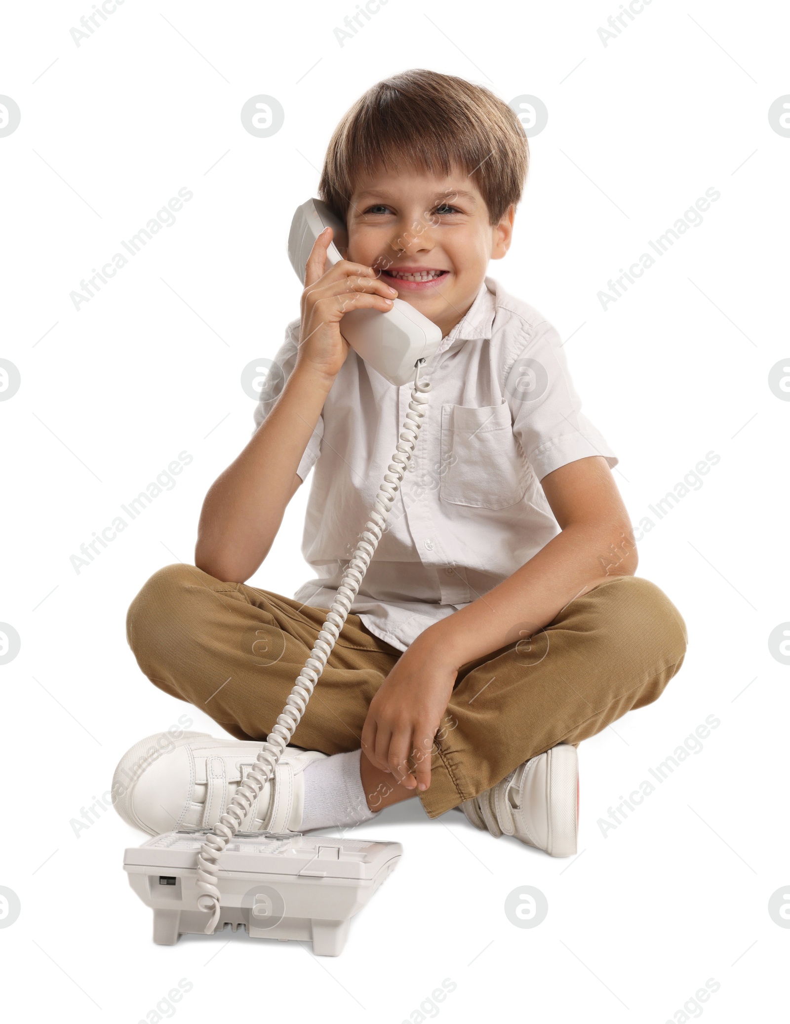 Photo of Cute little boy with telephone on white background