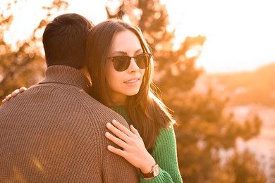 Cute couple enjoying their time together outdoors in autumn evening, space for text