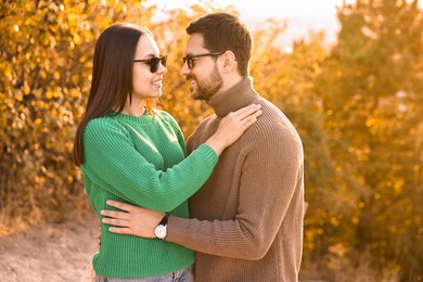 Beautiful happy couple hugging in autumn park