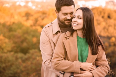 Beautiful couple outdoors on autumn day, space for text