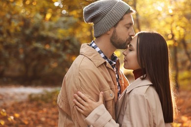 Beautiful couple spending time in park on autumn day, space for text