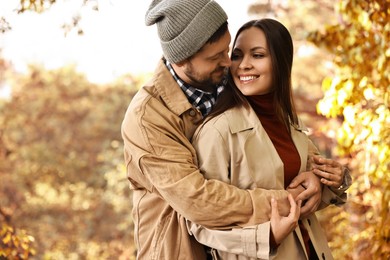 Photo of Beautiful happy couple hugging outdoors on autumn day