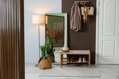 Photo of Stylish hallway interior with coat rack and mirror