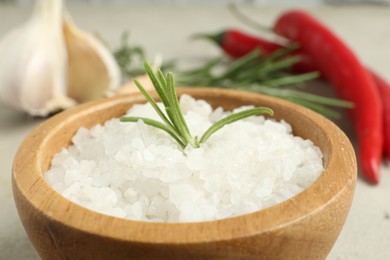 Photo of Sea salt and rosemary in bowl on table, closeup