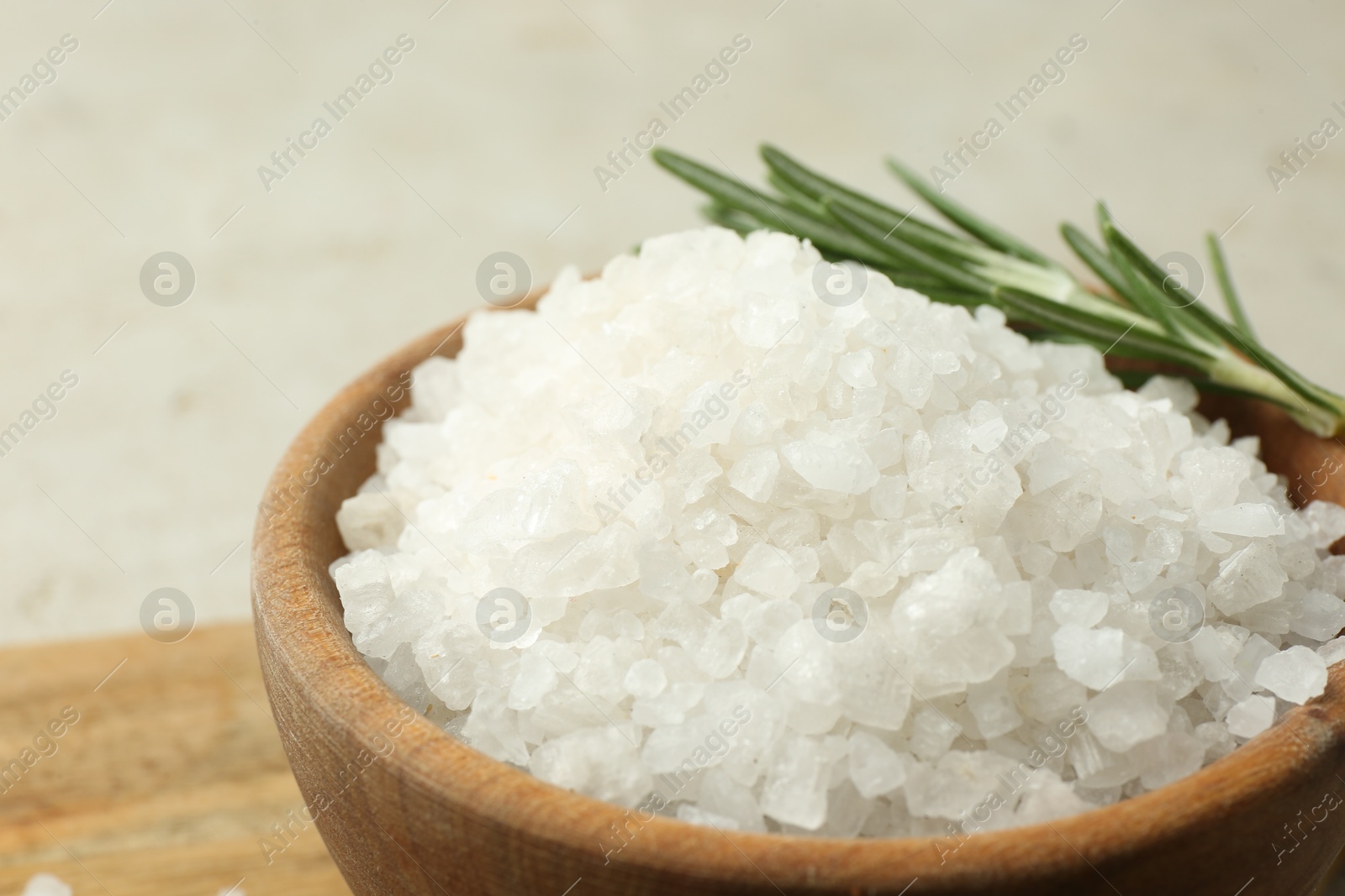 Photo of Sea salt and rosemary in bowl on table, closeup