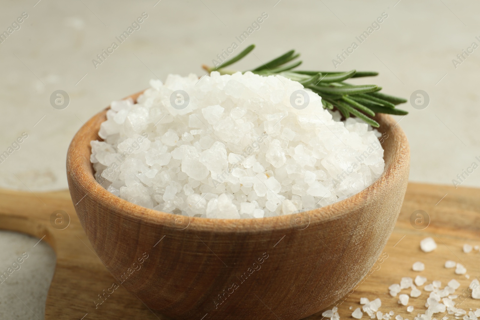 Photo of Sea salt and rosemary in bowl on table, closeup