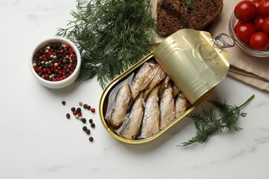 Tasty sprats in tin can, dill, peppercorns, bread and tomatoes on white marble table, top view