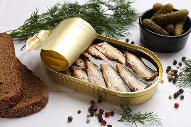 Tasty sprats in tin can served on white table