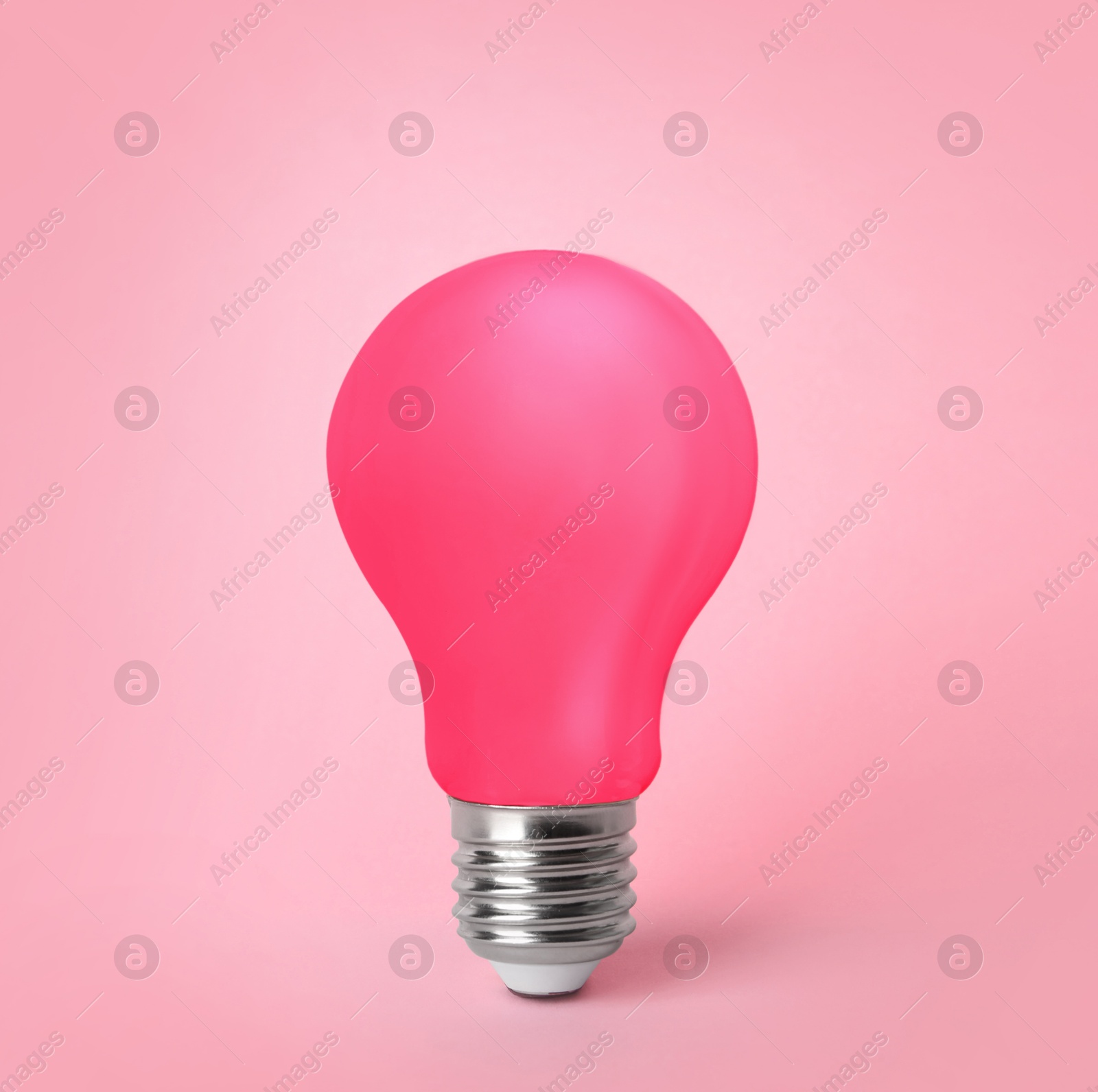 Image of One pink light bulb on pink background