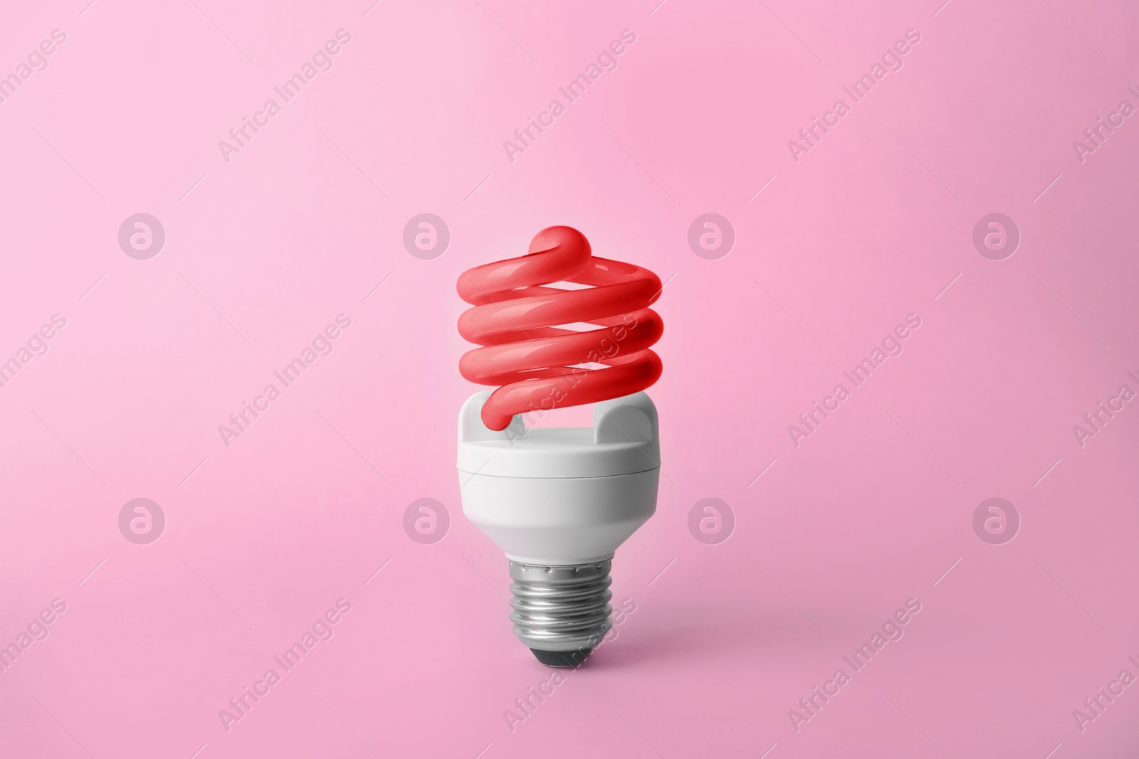 Image of Red fluorescent lamp bulb on pink background