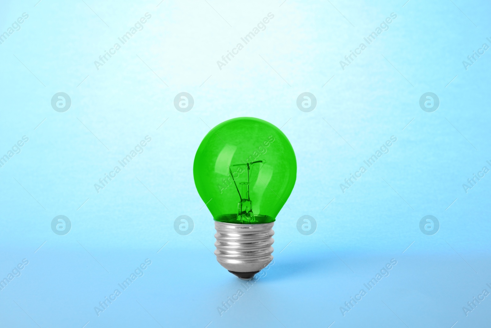 Image of One green bulb on light blue background