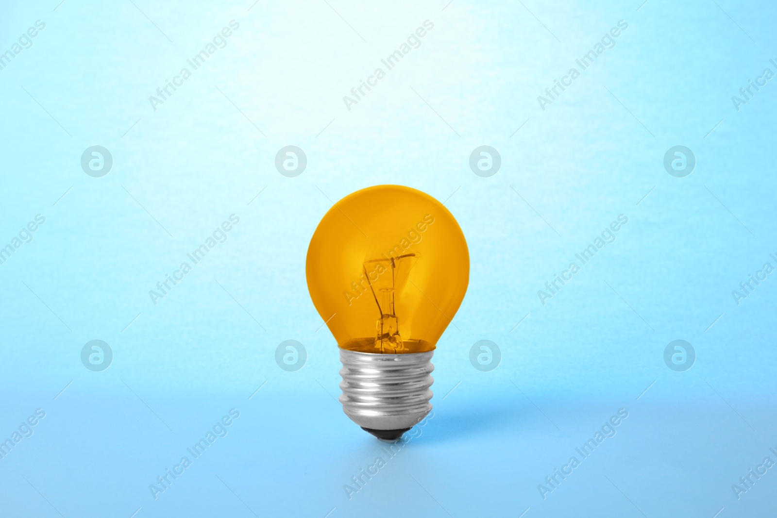 Image of One orange bulb on light blue background