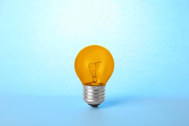 Image of One orange bulb on light blue background