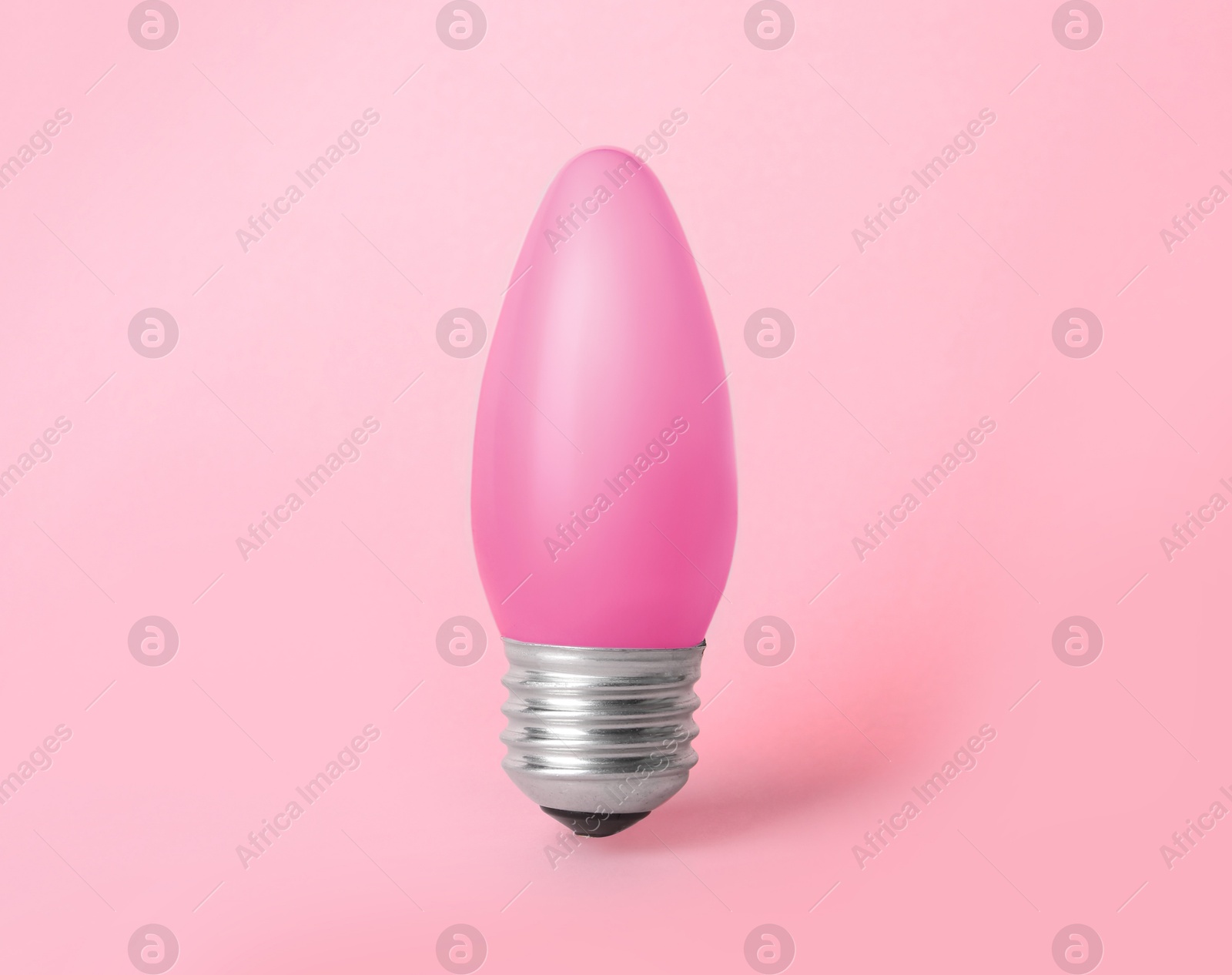 Image of One pink light bulb on pink background