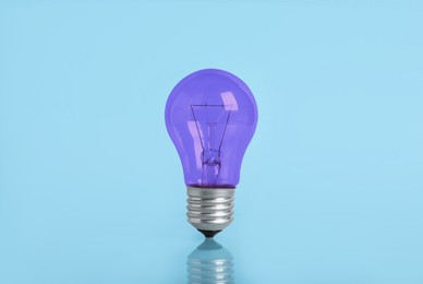 Image of One purple bulb on light blue background