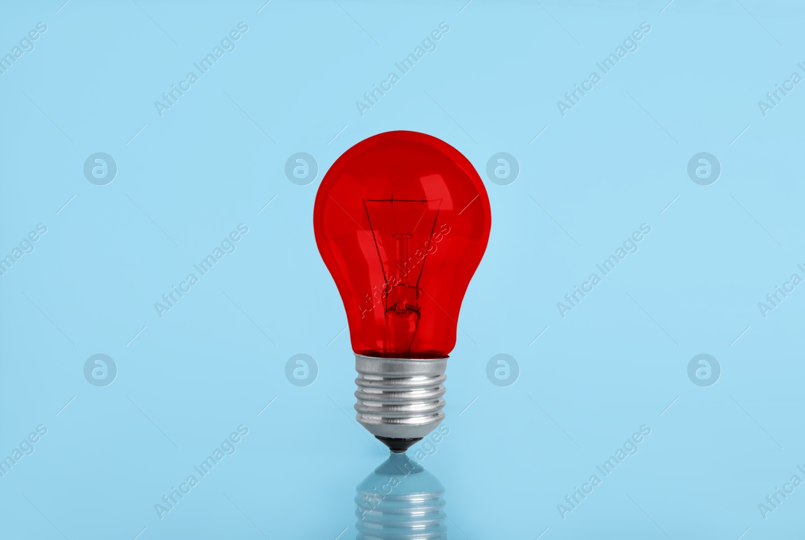 Image of One red bulb on light blue background