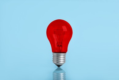 Image of One red bulb on light blue background