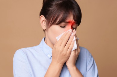 Image of Woman with tissue suffering from sinusitis on dark beige background