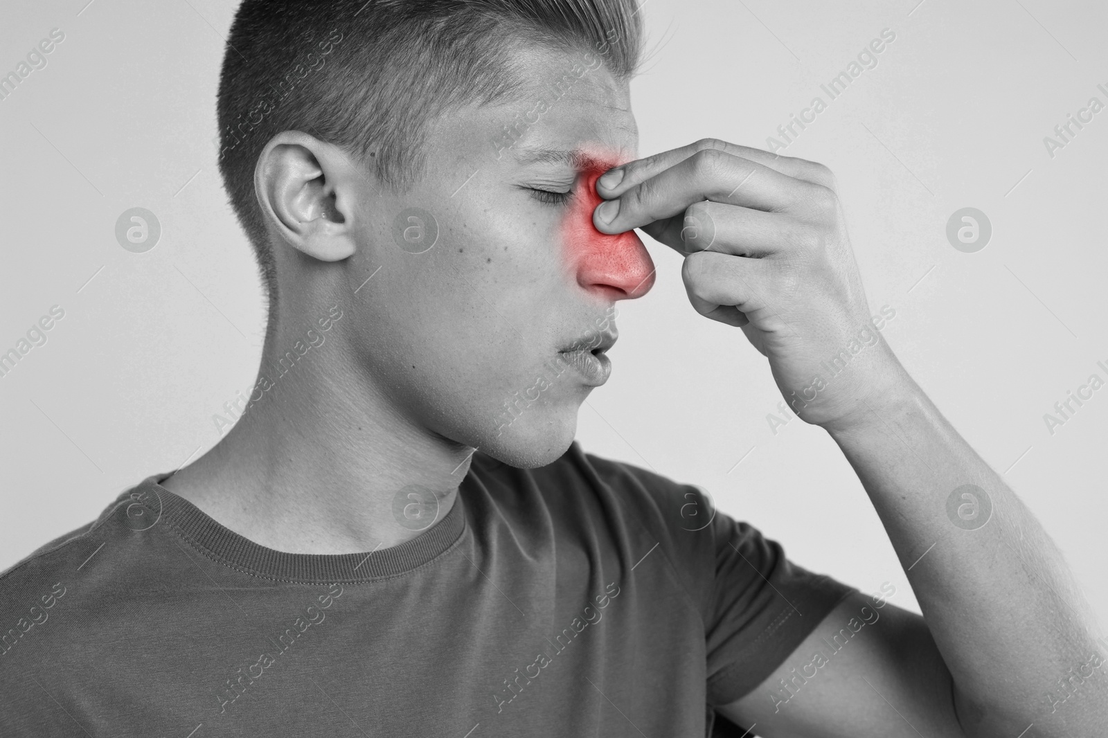 Image of Young man suffering from sinusitis. Black and white effect with red color accent