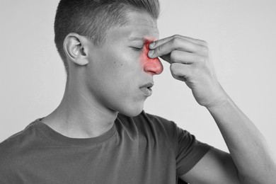 Young man suffering from sinusitis. Black and white effect with red color accent