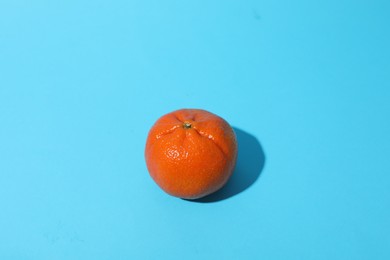 Photo of Fresh ripe tangerine on light blue background