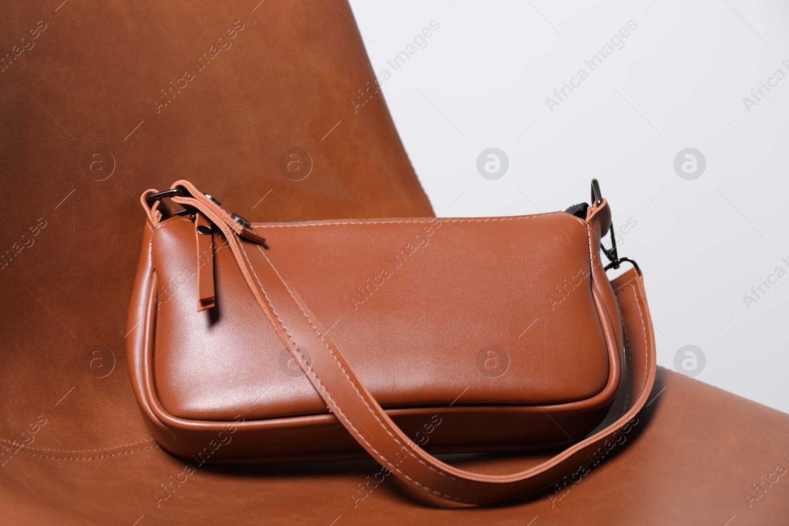 Photo of Stylish brown leather bag on chair, closeup