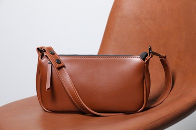 Stylish brown leather bag on chair, closeup