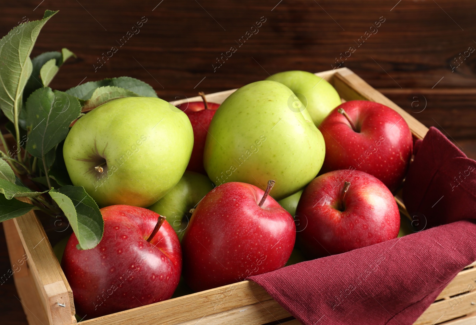 Photo of Ripe red and green apples in wooden crate, closeup