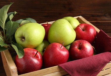 Photo of Ripe red and green apples in wooden crate, closeup