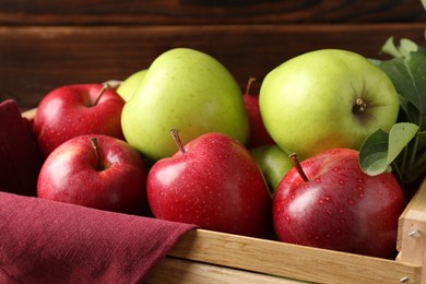 Photo of Ripe red and green apples in wooden crate, closeup