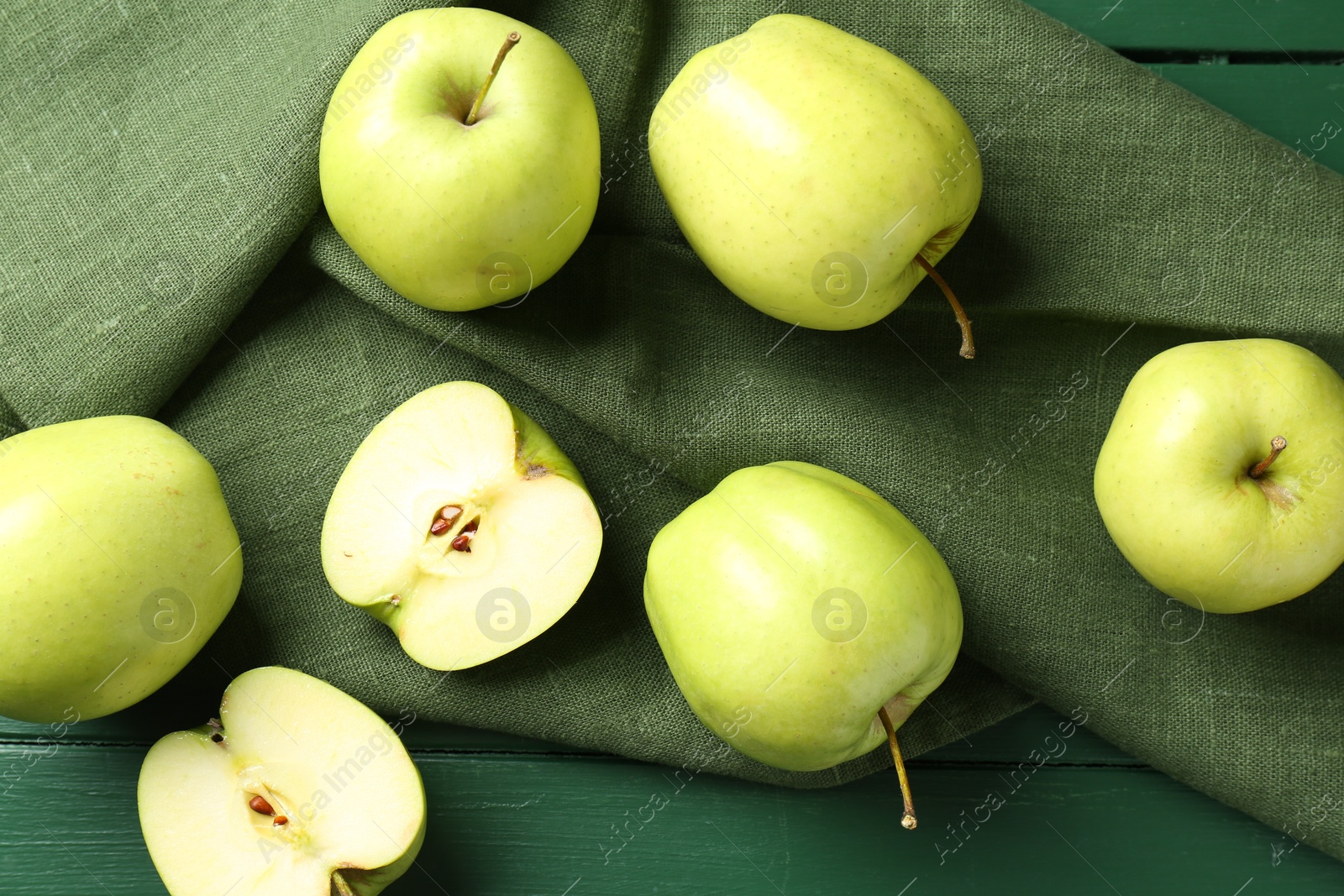 Photo of Ripe apples on green wooden table, top view