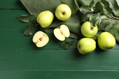 Photo of Ripe apples and leaves on green wooden table, top view