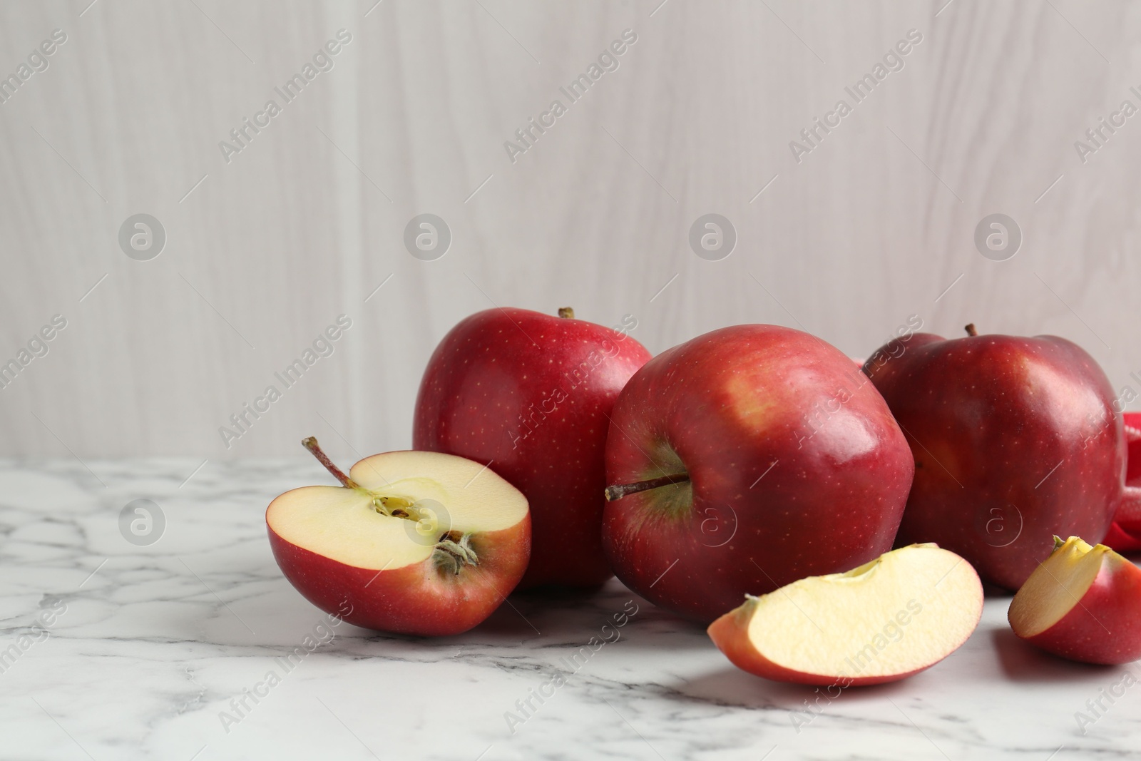 Photo of Ripe red apples on white marble table