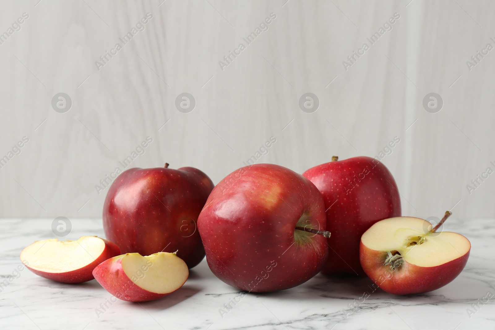 Photo of Ripe red apples on white marble table