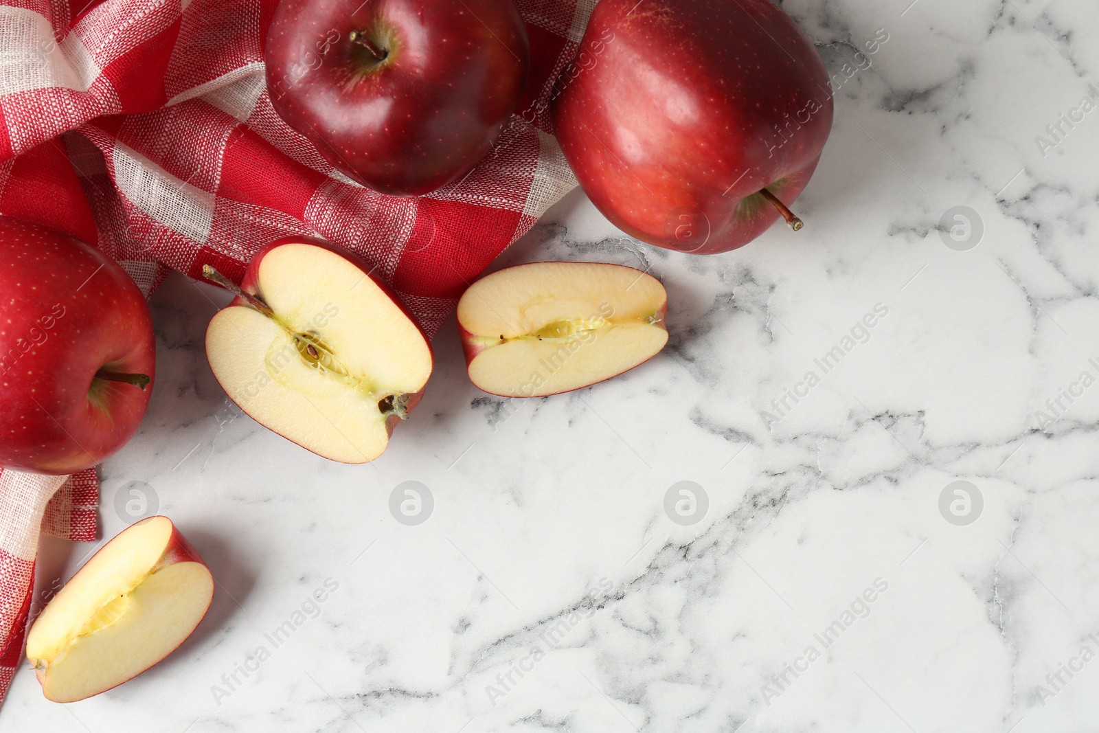 Photo of Ripe red apples on white marble table, top view. Space for text