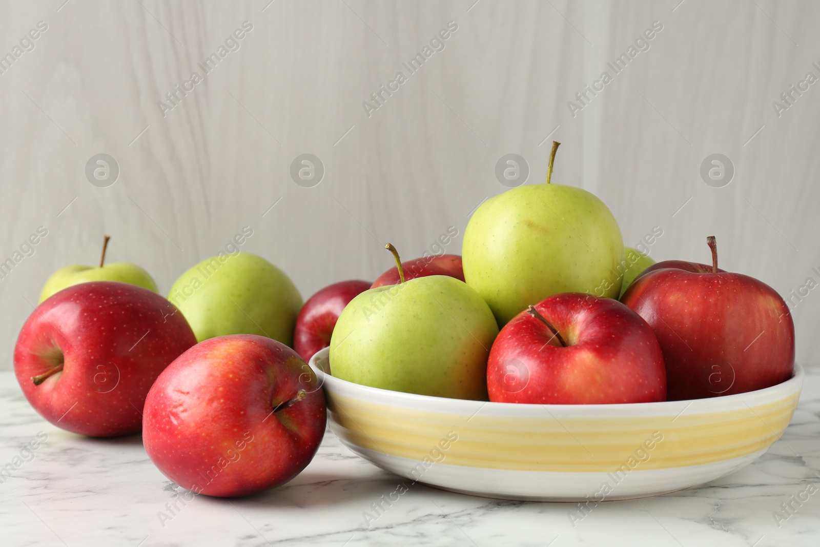 Photo of Ripe red and green apples on white marble table