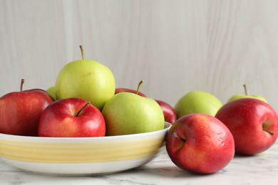 Photo of Ripe red and green apples on white marble table