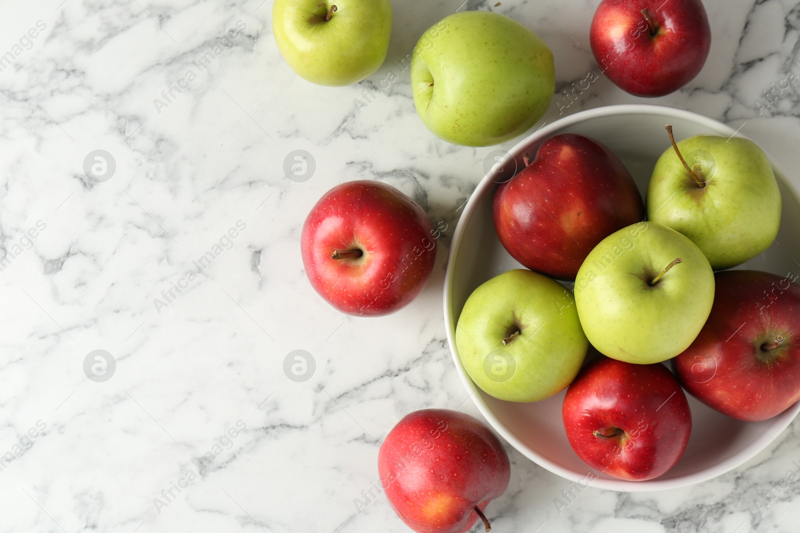 Photo of Ripe red and green apples on white marble table, top view. Space for text